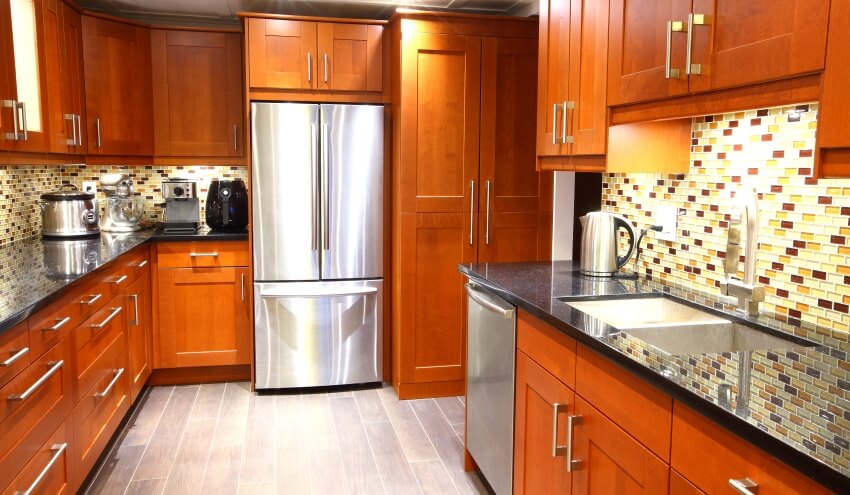 Modern kitchen with mosaic backsplash, black galaxy granite countertops, and glossy wooden cabinets