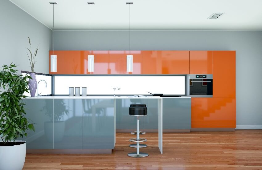 Modern kitchen with multi-colored laminate cabinets, pendant lights, and wooden floor