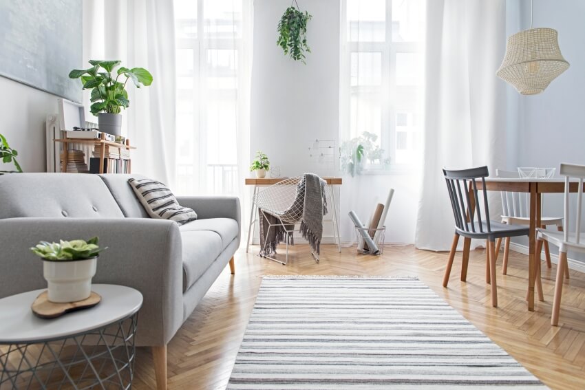 Modern living area with sofa, family table, rug and wooden desk