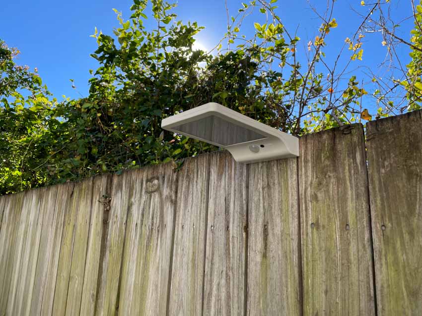 Modern motion sensor light on wood fence