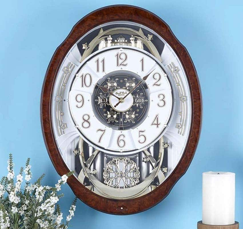Musical clock hanging on blue wall