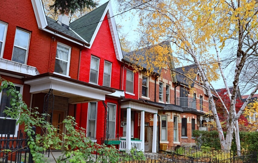 Narrow Victorian row houses with painted exterior bricks, porches, and gables