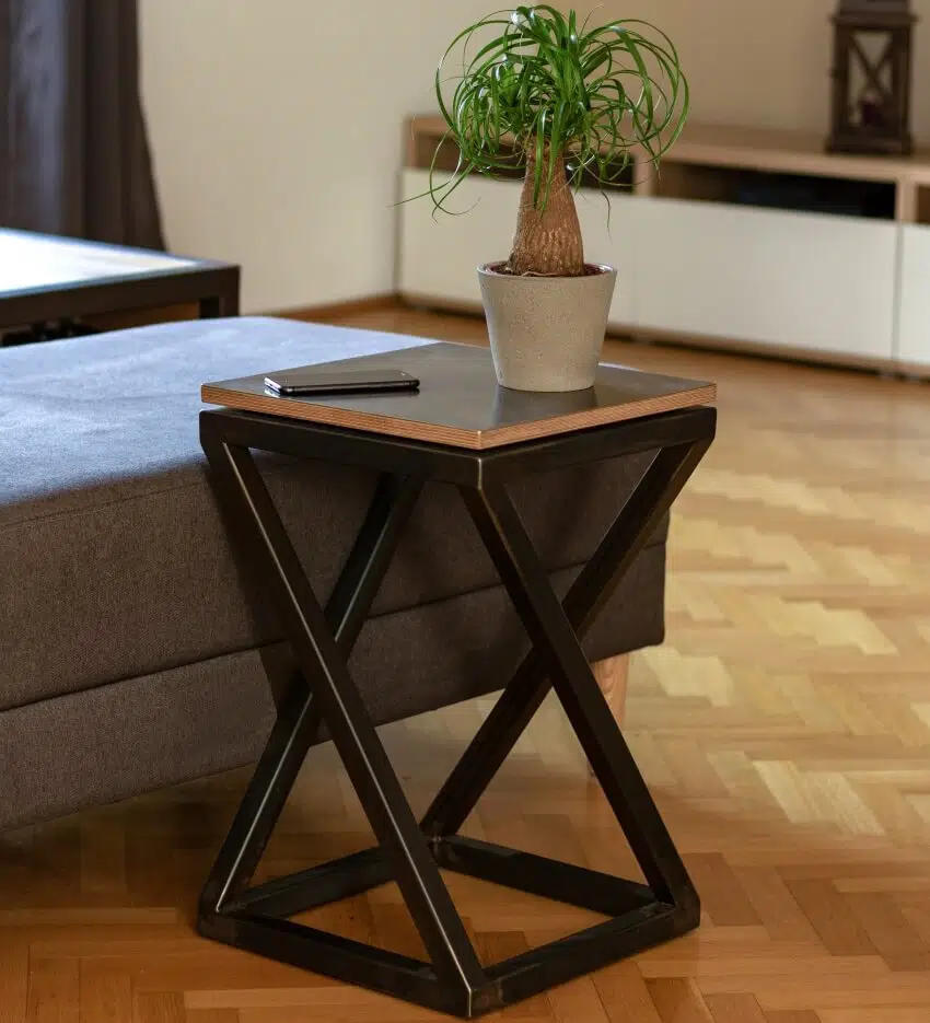 Nicely decorated coffee table with x-shaped legs on parquet floor