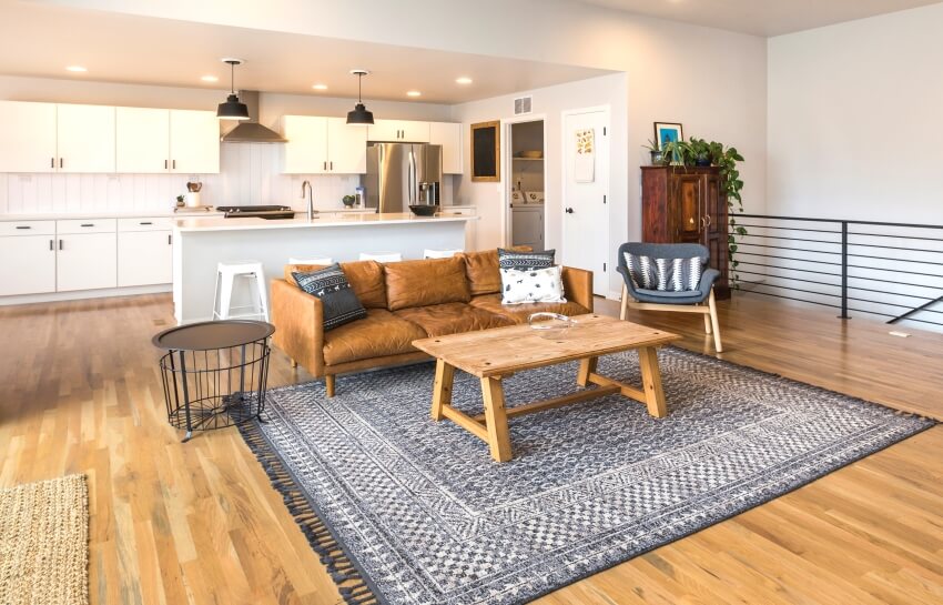 Open concept living space with carpet, leather sofa and wood table