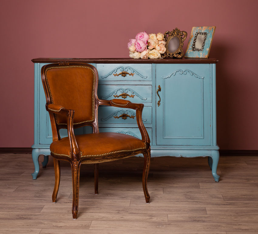 Orange accent armchair on wood flooring, and blue dresser