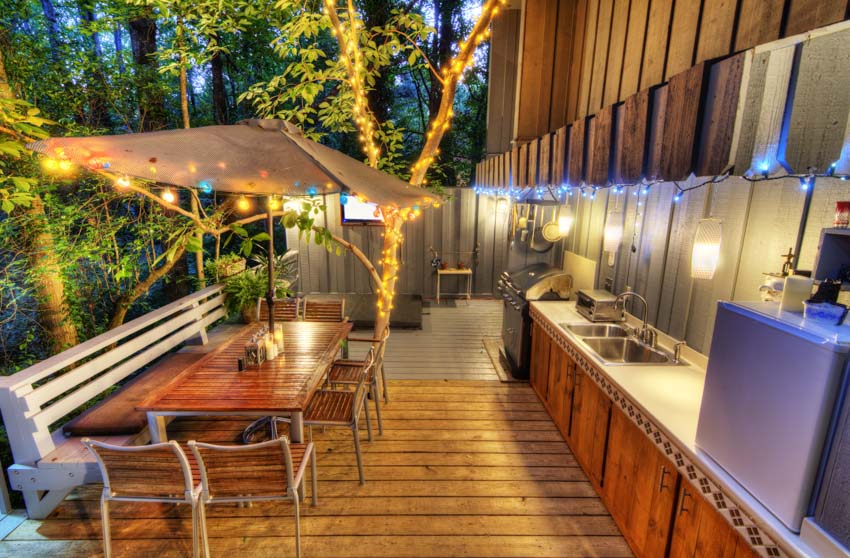 Outdoor area with lighting fixtures, wood flooring, countertop, table, and chairs