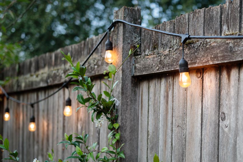 Outdoor area with wood fences, and string lights