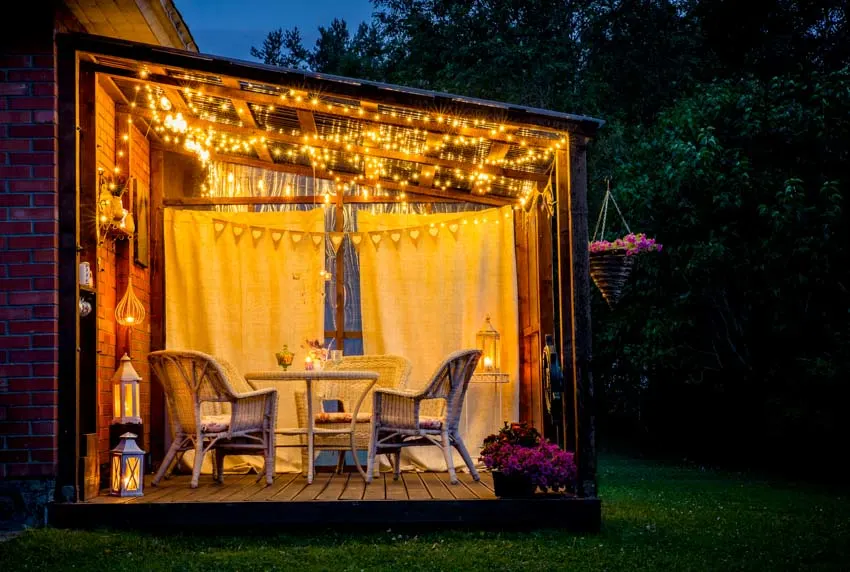 Outdoor patio area with string lights, chairs, and tables
