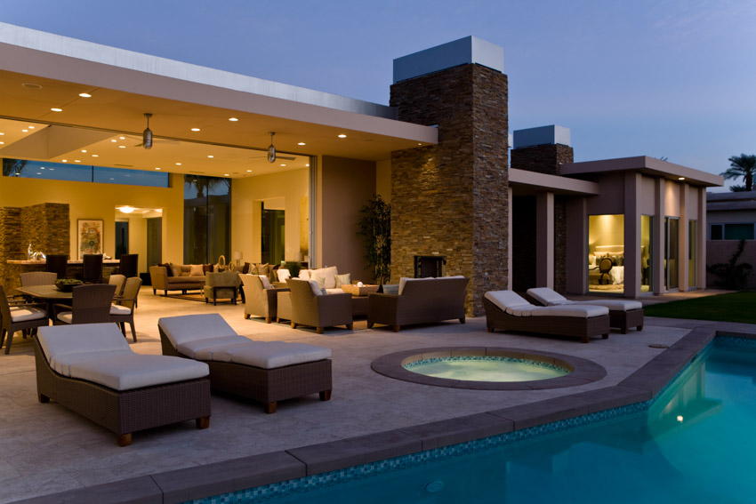 Outdoor patio deck with pool, lounge chairs, and recessed lights