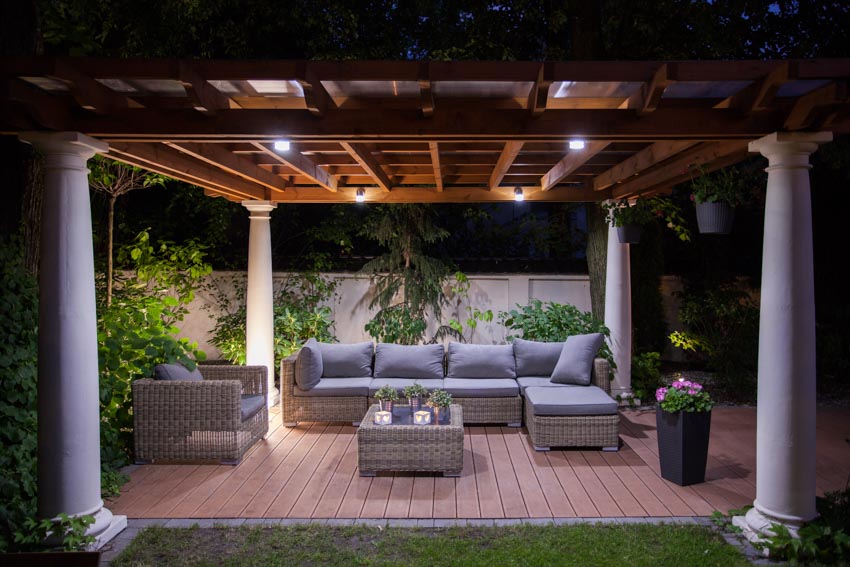 Outdoor patio with pergola, track lights, couch, chairs, and wood flooring