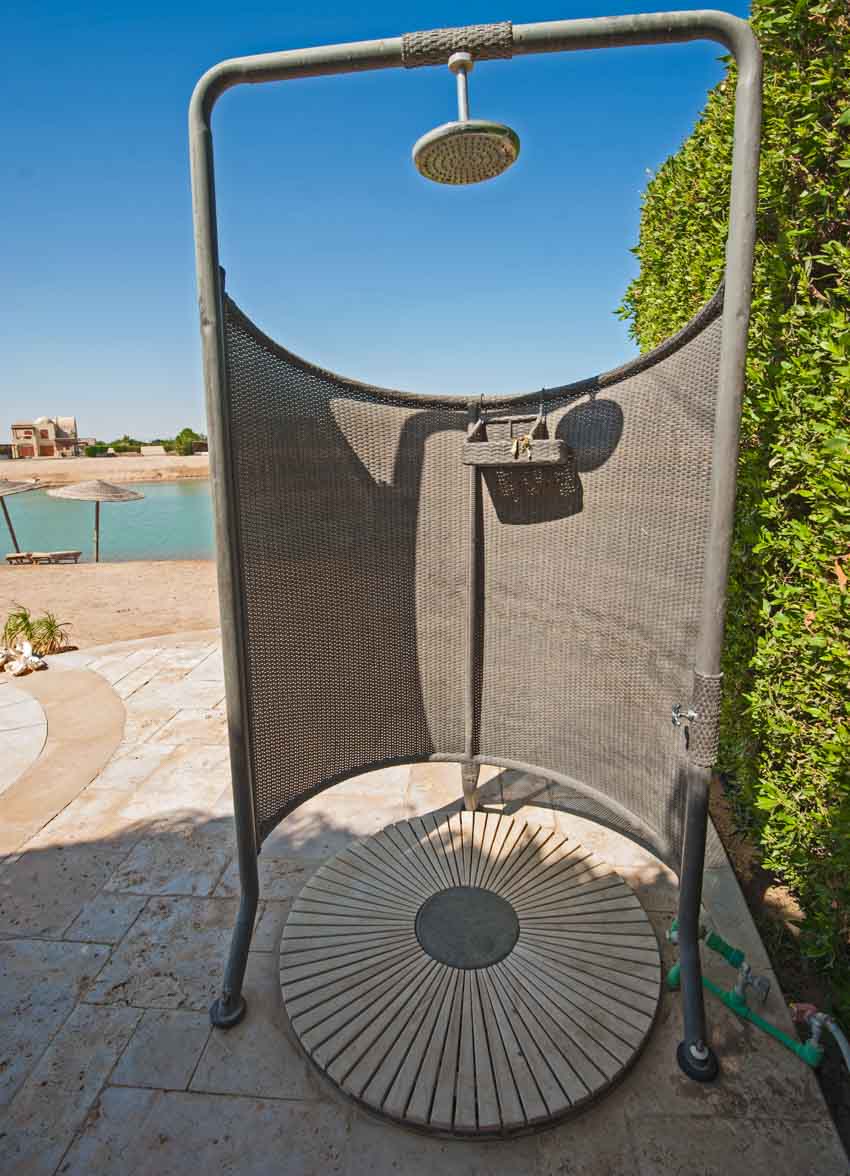 Outdoor shower with shower head, and drain near pool