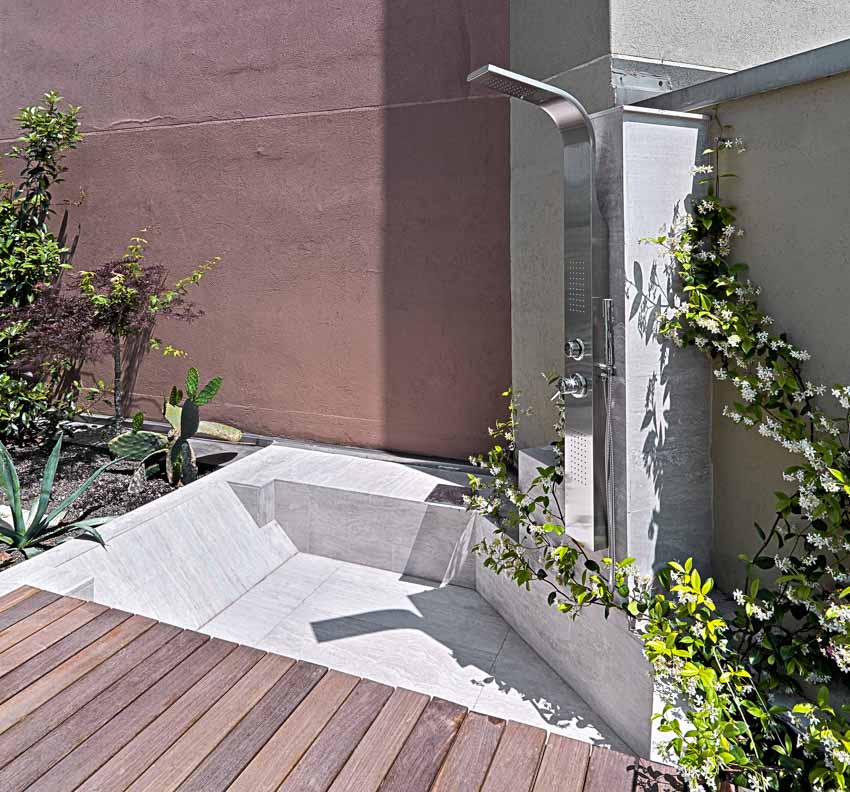 Sandstone wall, modern shower and wooden flooring