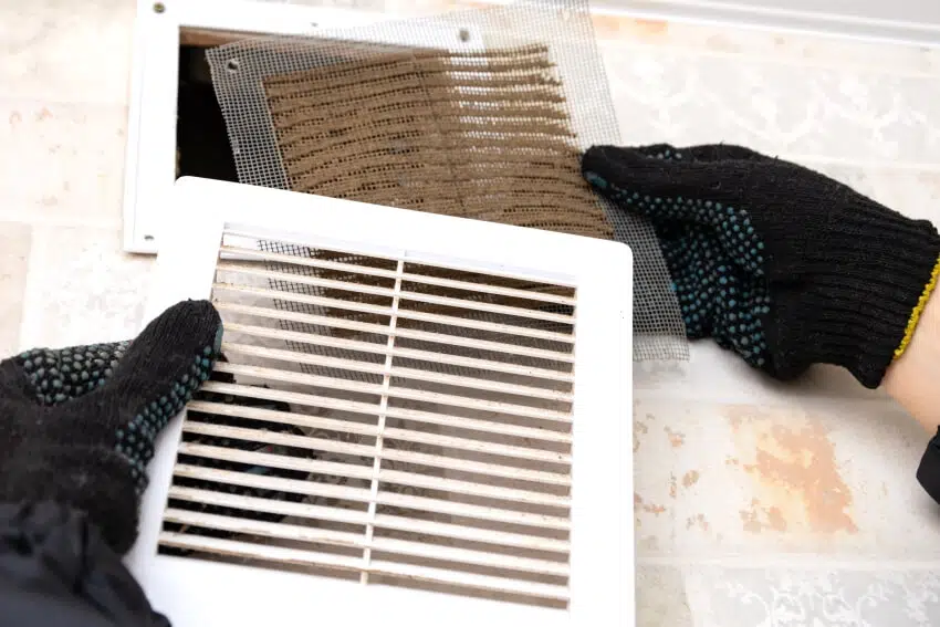 Repair service man removing a dirty air filter of a ventilation