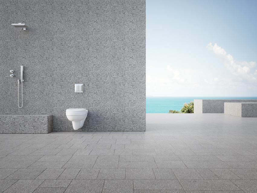 Shower with toilet behind a wide concrete wall