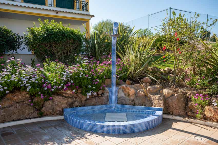 Shower with traditional ceramic mosaic design in blue with platform to stand on