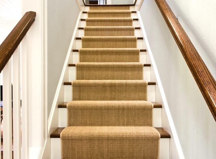Stairs with carpet runner and wood handrail