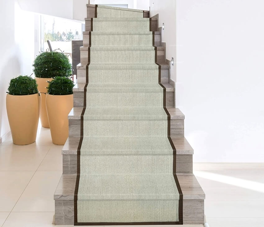 Stairs with synthetic sisal carpet runner and large vases on the side