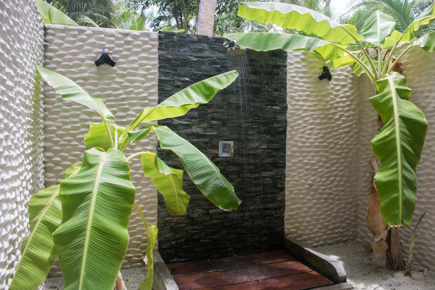 Tropical outdoor shower with stone wall, and dual shower head