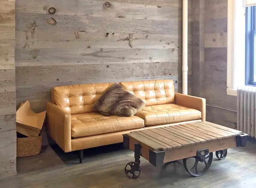 Vintage coffee table and leather sofa in a lounge with wooden walls