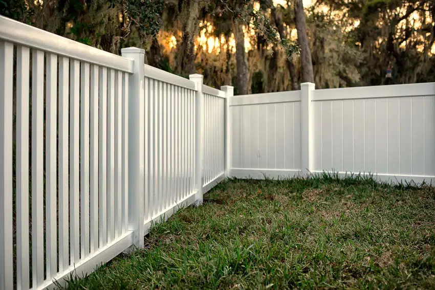 White composite fencing and grassy lawn