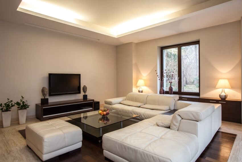 White living room with marble floor, ceiling lights, leather sofa, and a glass coffee table
