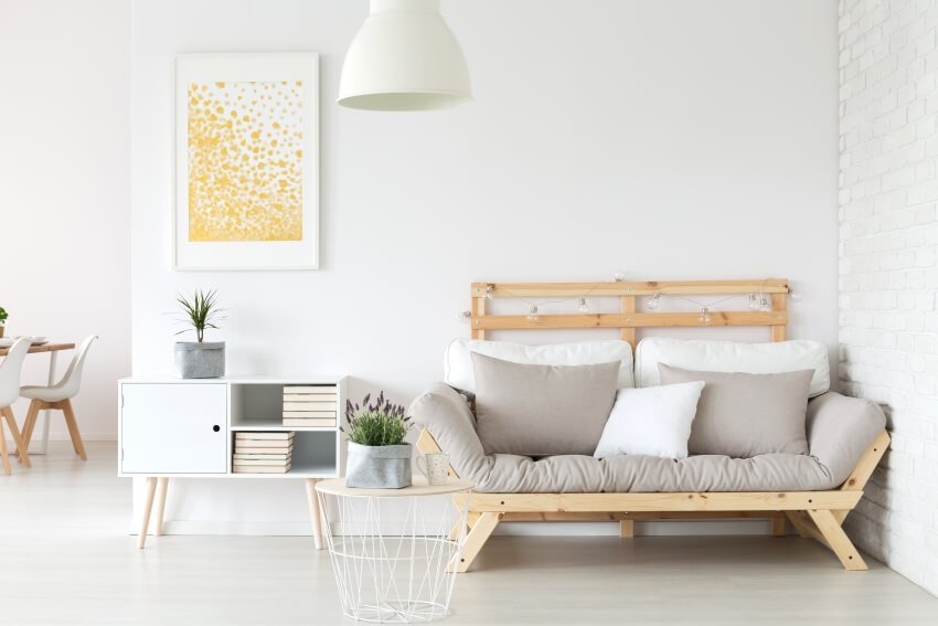 White room with wooden sofa and accent wall