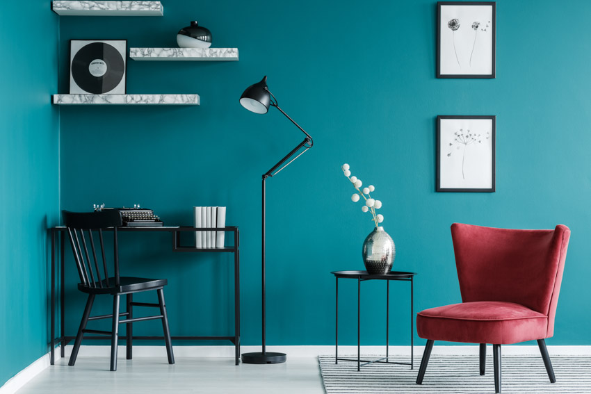 Workspace with accent chair, study table, blue green wall, and floor lamp