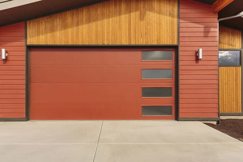Maroon garage door with accent lighting clapboard siding