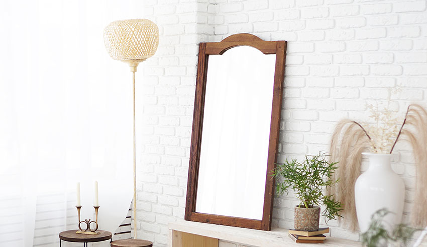 White walls, mirror with wood frame and large lampshade