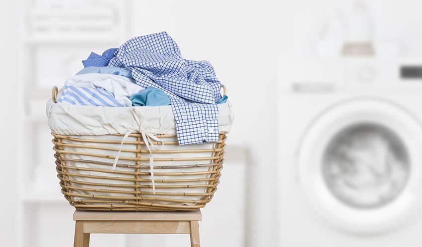 Rattan laundry storage basket next to washer and dryer