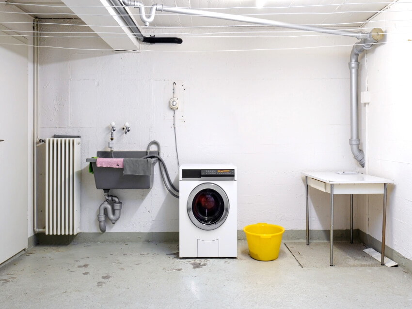 Basement room with washing machine, sink and piping