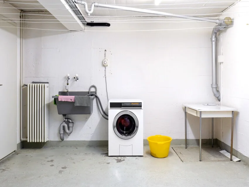 Basement room with washing machine, sink and piping