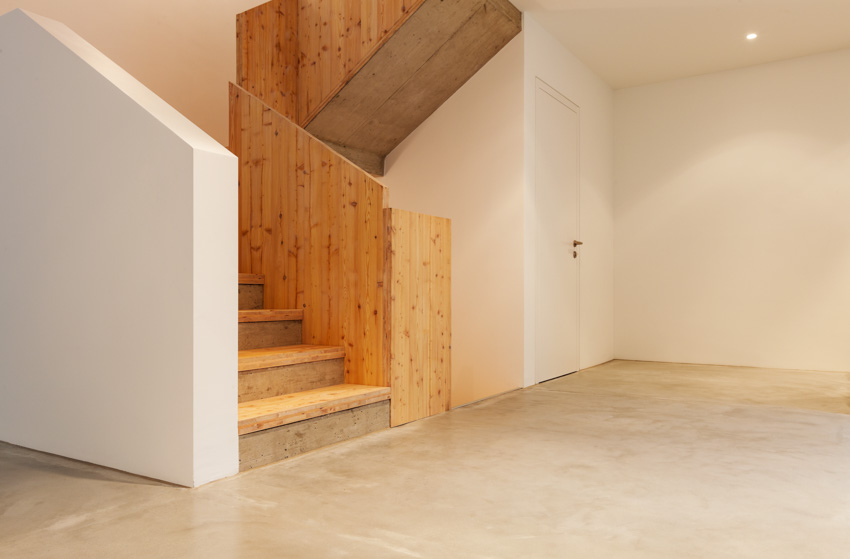 Basement with painted epoxy floor and wood staircase