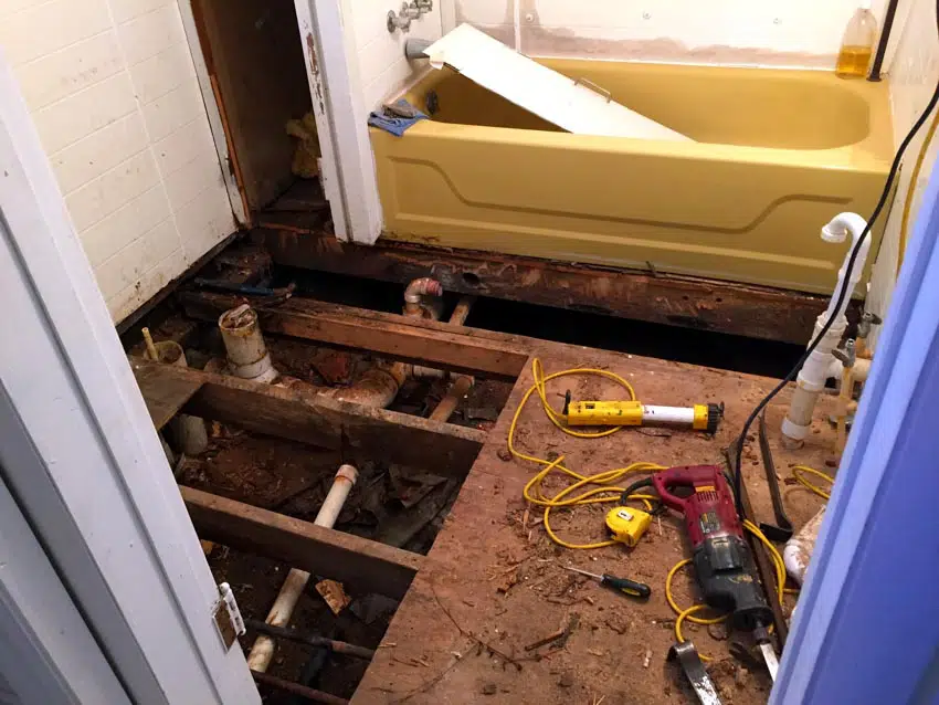 Bathroom floor being pulled apart to reveal mold 