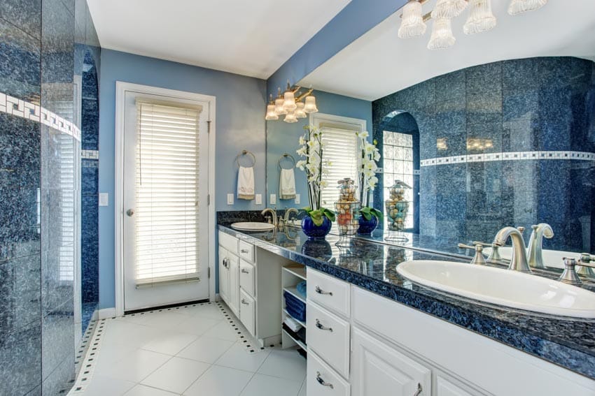 Bathroom with blue granite countertop, white drawers and tile flooring