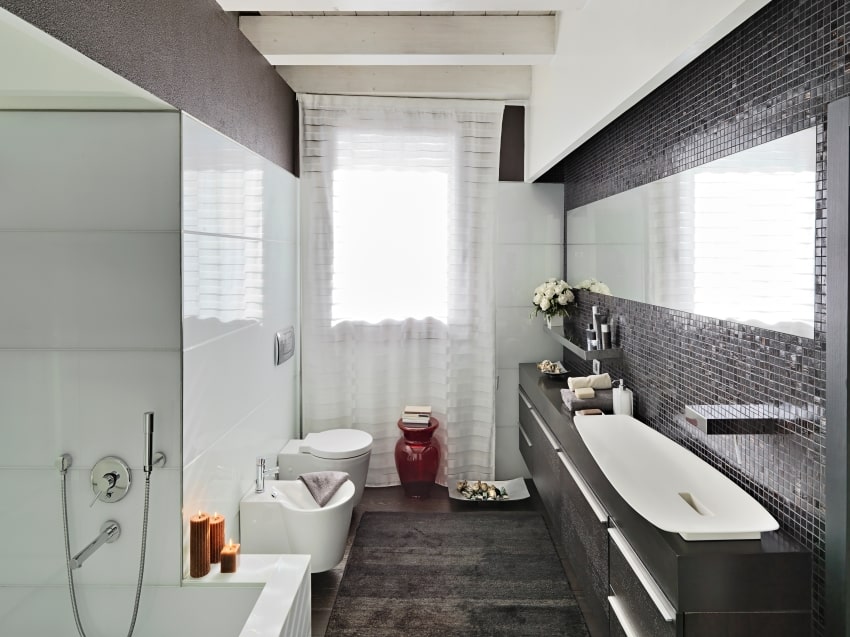 Bathroom with mosaic tile wall, ceiling beams, black carpet, and a dark vanity