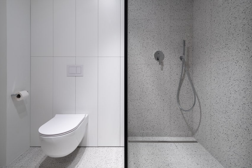 Bathroom with terrazzo shower wall, and toilet
