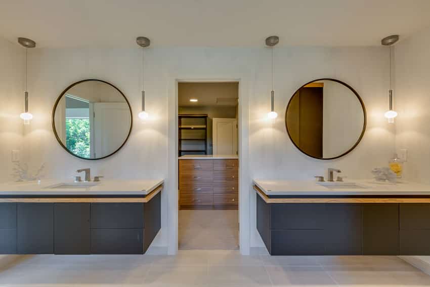 Bathroom with twin floating vanities, round mirrors and hanging lights