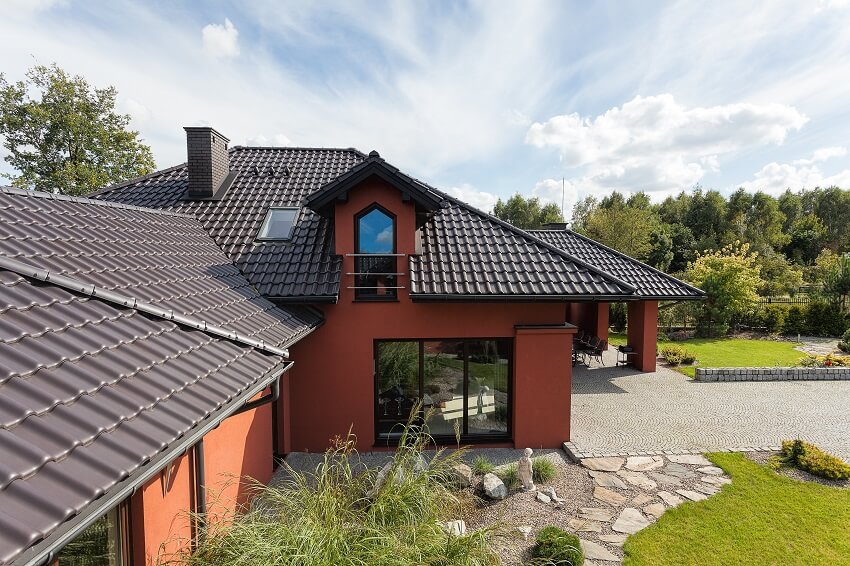 A beautiful house with clean tile roofing and gorgeous landscape