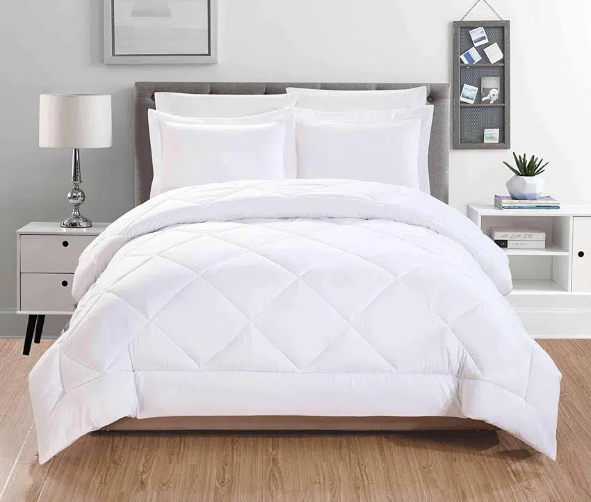 Comforter with geometric stitching and wood flooring