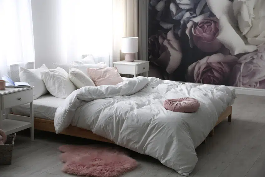 Bedroom with decorated wall and small pink rug
