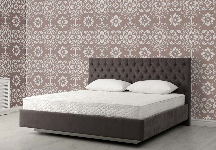 Bedroom with wallpaper, headboard, pillows, and latex mattress