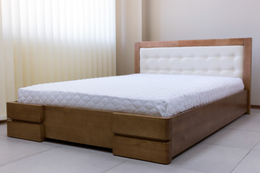 Bedroom with window curtain, latex mattress, wood frame, headboard, and tile floor 