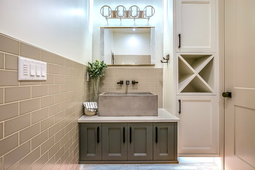 Big vessel concrete sink with subway tiles and storage cabinets 