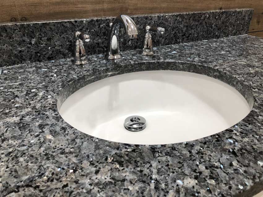 Black granite bathroom countertop with sink and faucet