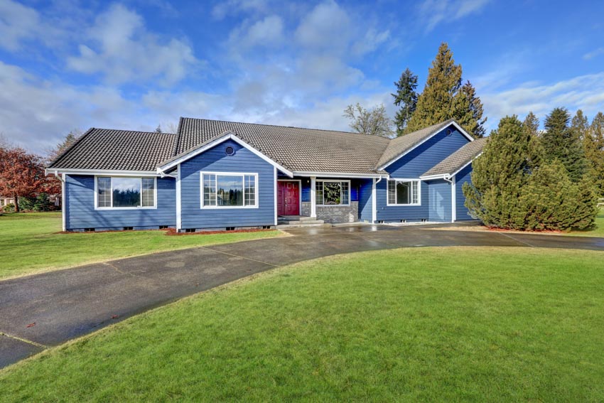 Blue house with curving epoxy sealed driveway, and grassy yard