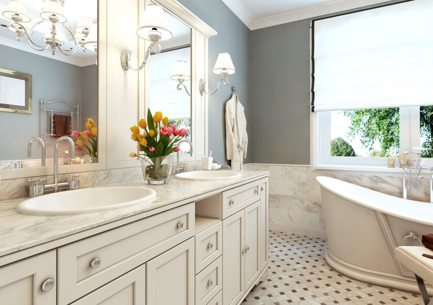 Bright classic bathroom with patterned tile floors, quartzite countertop, and sconce lights