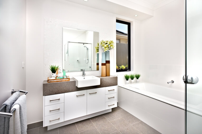 Bright white bathroom with a single sink vanity, bathtub, tile floor, and window