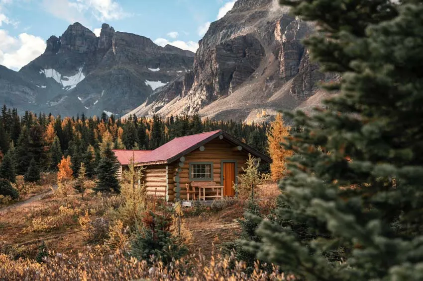 Cabin with red roof beside the mountain