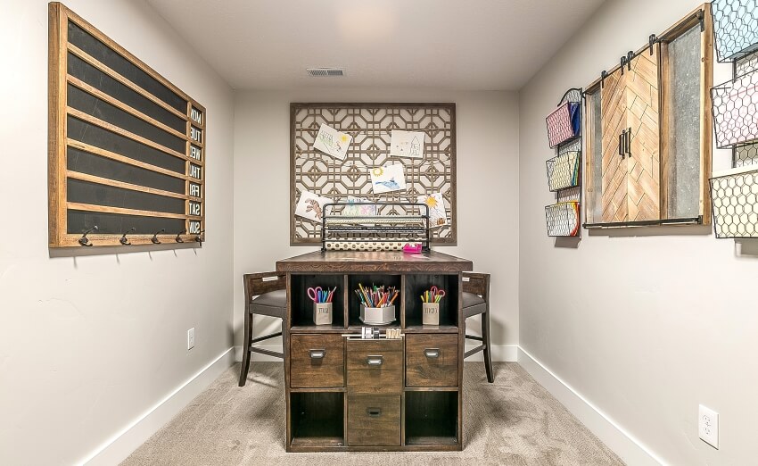 Carpeted craft room with wood cubby holes, stools, and organizers on cream colored wall